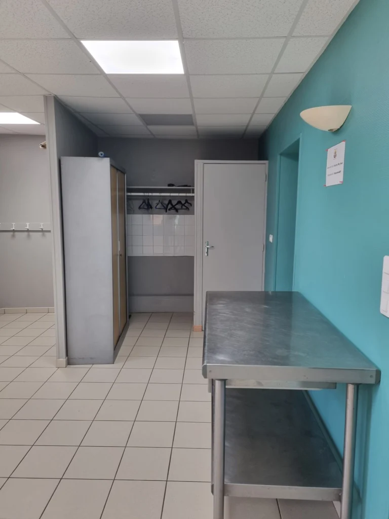 Entrée de la salle des fêtes avec rangements et table en inox.